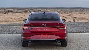 نمای عقب هیوندای النترا 2021 / 2021 Hyundai Elantra قرمز رنگ با منظره آسمان ابری